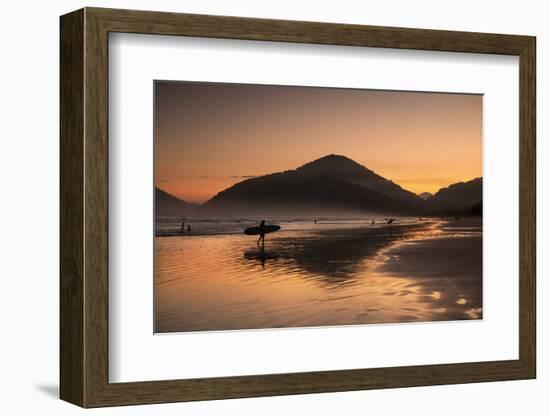 A Surfer Makes His Way Out of the Water at Sunset on Praia Do Itamambuca in Brazil-Alex Saberi-Framed Photographic Print