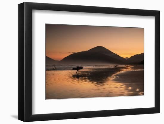 A Surfer Makes His Way Out of the Water at Sunset on Praia Do Itamambuca in Brazil-Alex Saberi-Framed Photographic Print