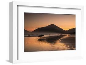 A Surfer Makes His Way Out of the Water at Sunset on Praia Do Itamambuca in Brazil-Alex Saberi-Framed Photographic Print