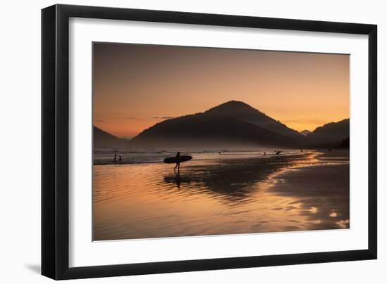 A Surfer Makes His Way Out of the Water at Sunset on Praia Do Itamambuca in Brazil-Alex Saberi-Framed Photographic Print