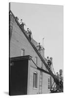 A Team of Firefighters With Hoses on Their Backs Climbs a Ladder-null-Stretched Canvas