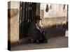 A Traditional Bolivian Woman Sits on a Doorstep in Potosi at Sunset-Alex Saberi-Stretched Canvas