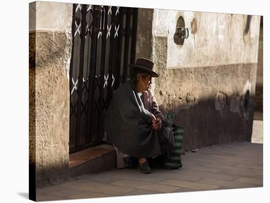 A Traditional Bolivian Woman Sits on a Doorstep in Potosi at Sunset-Alex Saberi-Stretched Canvas