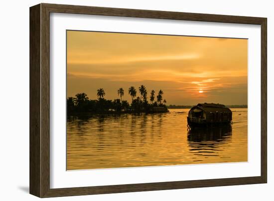 A traditional houseboat moves past the setting sun on the Kerala Backwaters, Kerala, India, Asia-Logan Brown-Framed Photographic Print