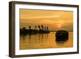 A traditional houseboat moves past the setting sun on the Kerala Backwaters, Kerala, India, Asia-Logan Brown-Framed Photographic Print