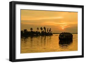 A traditional houseboat moves past the setting sun on the Kerala Backwaters, Kerala, India, Asia-Logan Brown-Framed Photographic Print