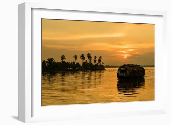 A traditional houseboat moves past the setting sun on the Kerala Backwaters, Kerala, India, Asia-Logan Brown-Framed Photographic Print