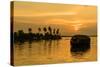 A traditional houseboat moves past the setting sun on the Kerala Backwaters, Kerala, India, Asia-Logan Brown-Stretched Canvas