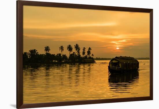 A traditional houseboat moves past the setting sun on the Kerala Backwaters, Kerala, India, Asia-Logan Brown-Framed Photographic Print