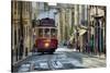 A tramway in Alfama district with the Motherchurch (Se Catedral) in the background. Lisbon, Portuga-Mauricio Abreu-Stretched Canvas