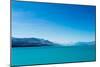 A turquoise blue lake with snow covered mountains in the distance, South Island, New Zealand-Logan Brown-Mounted Photographic Print