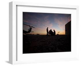 A UH-60 Black Hawk Crew Carry Out a Mission Brief at Sunset-null-Framed Photographic Print