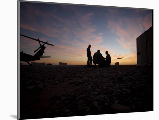 A UH-60 Black Hawk Crew Carry Out a Mission Brief at Sunset-null-Mounted Photographic Print