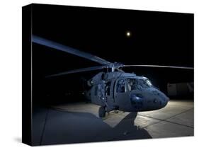 A UH-60 Black Hawk Helicopter Parked on the Flight Line under a Full Moon-null-Stretched Canvas