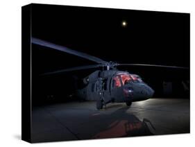 A UH-60 Black Hawk Helicopter Parked on the Flight Line under a Full Moon-null-Stretched Canvas