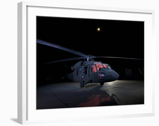 A UH-60 Black Hawk Helicopter Parked on the Flight Line under a Full Moon-null-Framed Photographic Print