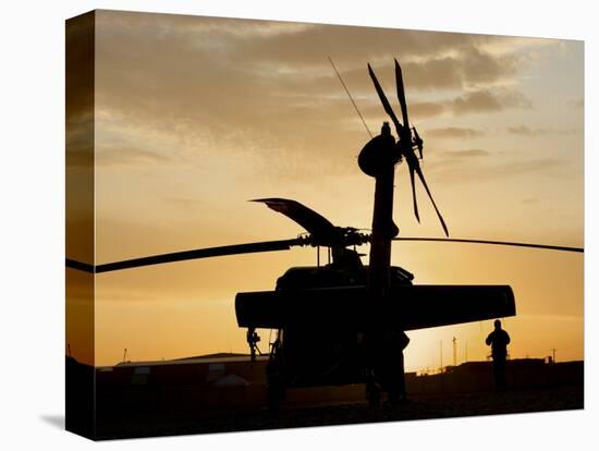 A UH-60L Black Hawk Helicopter Silhouetted by the Setting Sun-null-Stretched Canvas