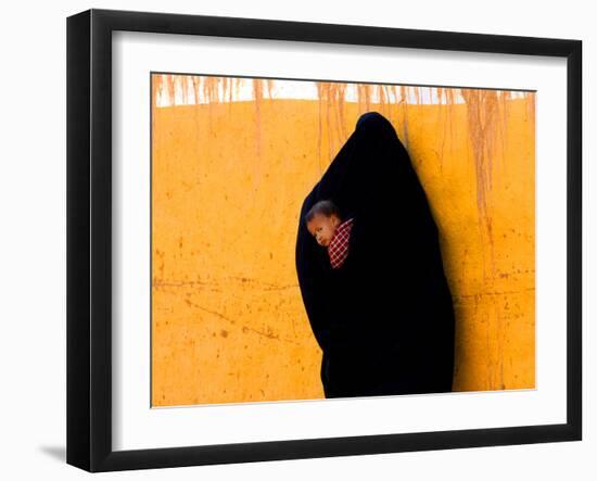 A Veiled Woman Carries Her Child Through the Streets of Erfoud-null-Framed Photographic Print