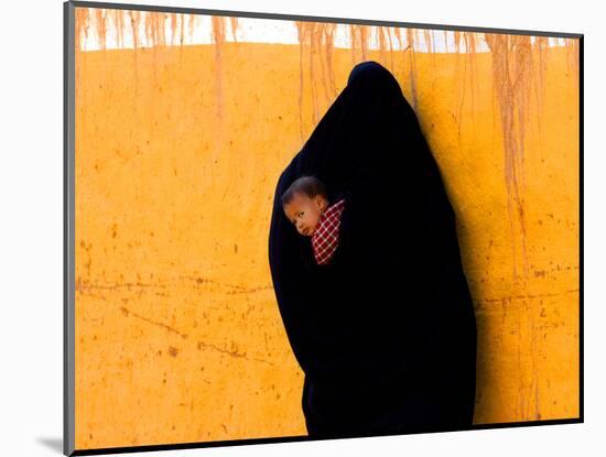 A Veiled Woman Carries Her Child Through the Streets of Erfoud-null-Mounted Photographic Print