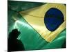 A Vendor Walks Behind a Big Brazilian Flag-null-Mounted Photographic Print