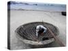 A Vietnamese Fisherman Does Repairs on His Basket Boat on a Beach-null-Stretched Canvas