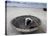 A Vietnamese Fisherman Does Repairs on His Basket Boat on a Beach-null-Stretched Canvas