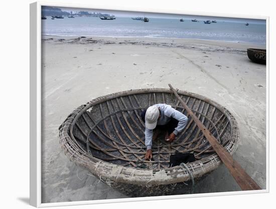 A Vietnamese Fisherman Does Repairs on His Basket Boat on a Beach-null-Framed Photographic Print