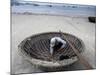 A Vietnamese Fisherman Does Repairs on His Basket Boat on a Beach-null-Mounted Photographic Print