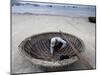A Vietnamese Fisherman Does Repairs on His Basket Boat on a Beach-null-Mounted Photographic Print