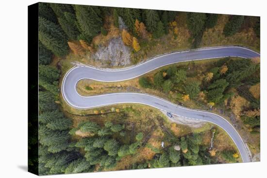 A view by drone of a winding road in the Dolomites, Italy-Julian Elliott-Stretched Canvas