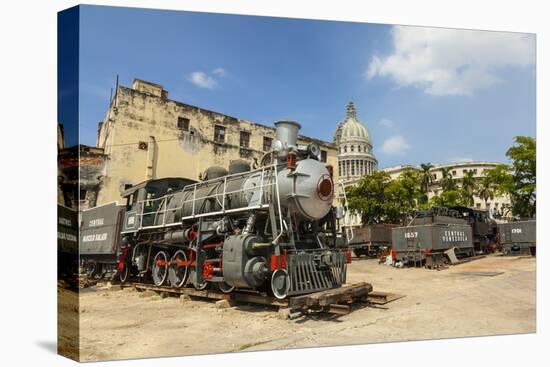 A Vintage Steam Train in a Restoration Yard with Dome of Former Parliament Building in Background-Sean Cooper-Stretched Canvas