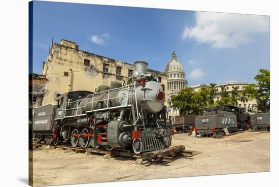 A Vintage Steam Train in a Restoration Yard with Dome of Former Parliament Building in Background-Sean Cooper-Stretched Canvas