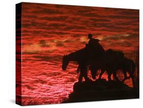 A Vivid Late-Autumn Sunset Silhouettes the Statue Known as Pioneer Mother at Penn Valley Park-null-Stretched Canvas