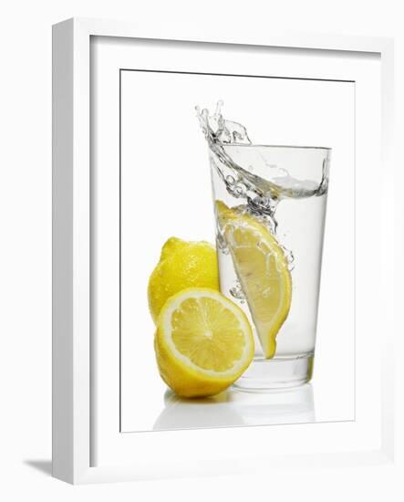 A Wedge of Lemon Falling into a Glass of Water-Kröger & Gross-Framed Photographic Print