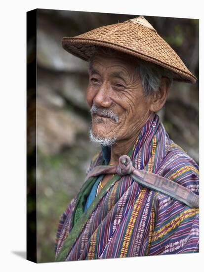 A Wizened Old Farmer Near Mongar Wears the Traditional Knee-Length National Robe Called Gho and a B-Nigel Pavitt-Stretched Canvas