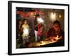 A Woman Lights Earthen Lamps as Children Ignite Firecrackers in New Delhi-Manish Swarup-Framed Photographic Print