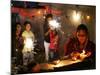A Woman Lights Earthen Lamps as Children Ignite Firecrackers in New Delhi-Manish Swarup-Mounted Photographic Print