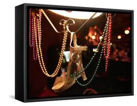 A Woman's High Heeled Shoe Hangs with Some Mardi Gras Beads-null-Framed Stretched Canvas