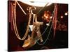 A Woman's High Heeled Shoe Hangs with Some Mardi Gras Beads-null-Stretched Canvas