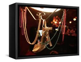 A Woman's High Heeled Shoe Hangs with Some Mardi Gras Beads-null-Framed Stretched Canvas