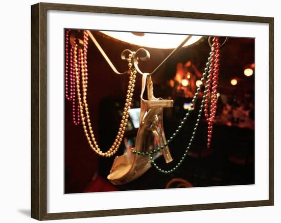 A Woman's High Heeled Shoe Hangs with Some Mardi Gras Beads-null-Framed Photographic Print