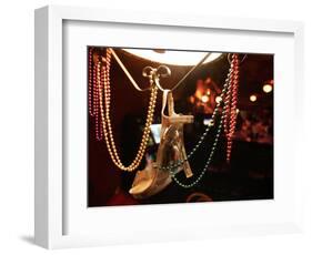 A Woman's High Heeled Shoe Hangs with Some Mardi Gras Beads-null-Framed Photographic Print