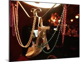 A Woman's High Heeled Shoe Hangs with Some Mardi Gras Beads-null-Mounted Photographic Print