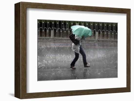 A Woman Struggles to Hold an Umbrella as She Walks Through a Storm in Beijing-David Gray-Framed Photographic Print
