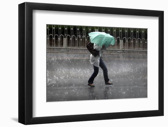 A Woman Struggles to Hold an Umbrella as She Walks Through a Storm in Beijing-David Gray-Framed Photographic Print