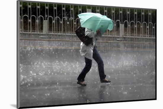 A Woman Struggles to Hold an Umbrella as She Walks Through a Storm in Beijing-David Gray-Mounted Photographic Print