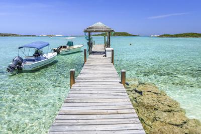 https://imgc.allpostersimages.com/img/posters/a-wood-pier-leads-to-moored-boats-and-clear-tropical-waters-near-staniel-cay-exuma-bahamas_u-L-Q13AQGY0.jpg?artPerspective=n