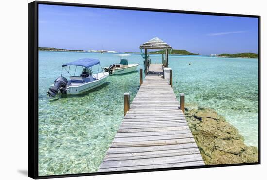 A Wood Pier Leads to Moored Boats and Clear Tropical Waters Near Staniel Cay, Exuma, Bahamas-James White-Framed Stretched Canvas