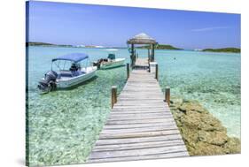 A Wood Pier Leads to Moored Boats and Clear Tropical Waters Near Staniel Cay, Exuma, Bahamas-James White-Stretched Canvas