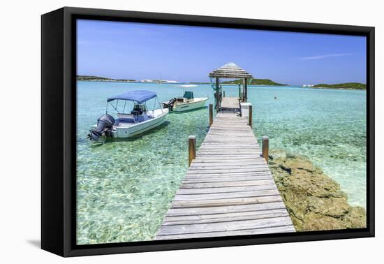 A Wood Pier Leads to Moored Boats and Clear Tropical Waters Near Staniel Cay, Exuma, Bahamas-James White-Framed Stretched Canvas